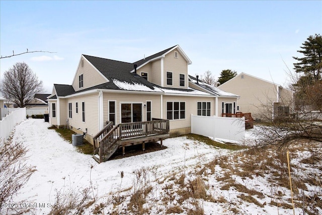 snow covered house featuring central AC and a wooden deck