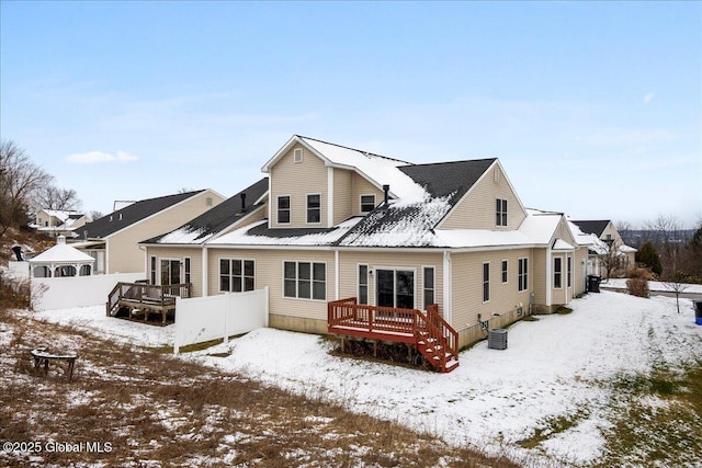 snow covered house featuring a wooden deck