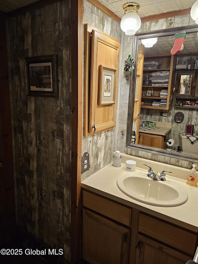 bathroom featuring vanity and wooden walls