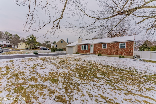 snow covered property with a garage