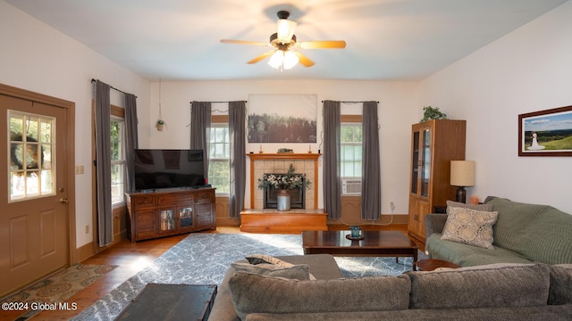 living room with cooling unit, ceiling fan, and light hardwood / wood-style flooring