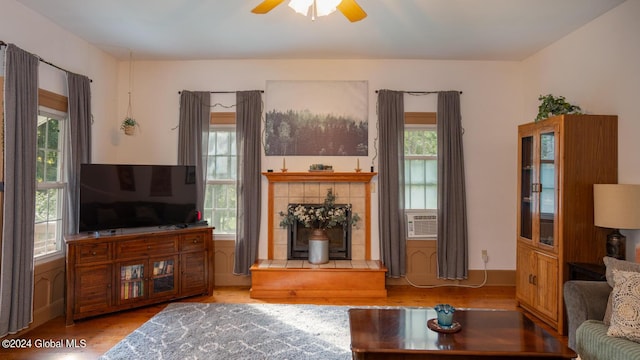 living room featuring cooling unit, light wood-type flooring, plenty of natural light, and ceiling fan