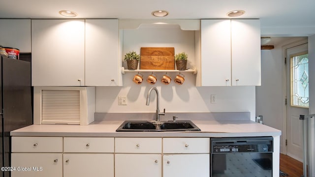 kitchen featuring sink, white cabinetry, wood-type flooring, and black appliances