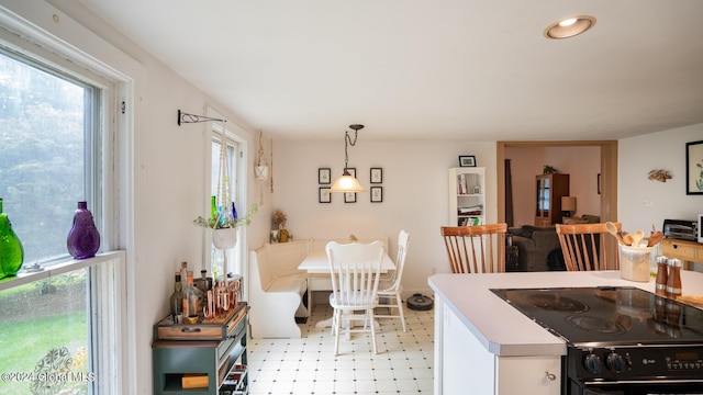 kitchen with black / electric stove, white cabinetry, and decorative light fixtures