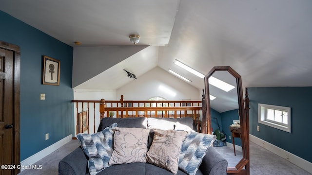 interior space featuring carpet flooring and vaulted ceiling with skylight