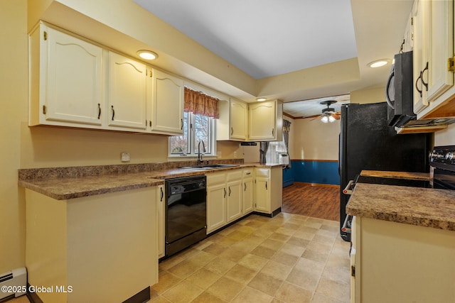 kitchen featuring sink, ceiling fan, baseboard heating, a tray ceiling, and black appliances