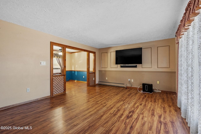 unfurnished living room with baseboard heating, ceiling fan, wood-type flooring, and a textured ceiling