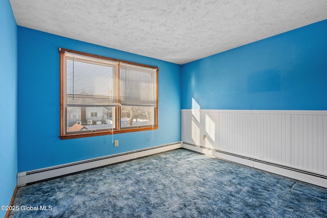 carpeted empty room featuring baseboard heating and a textured ceiling