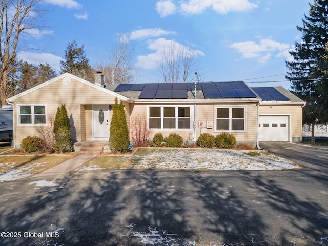 ranch-style home with solar panels and a garage