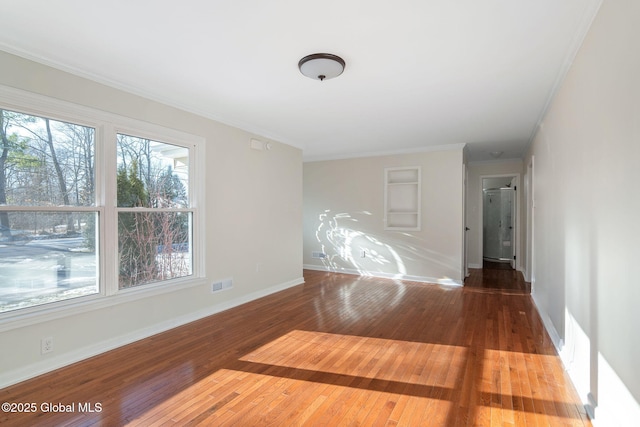 empty room featuring hardwood / wood-style flooring and ornamental molding