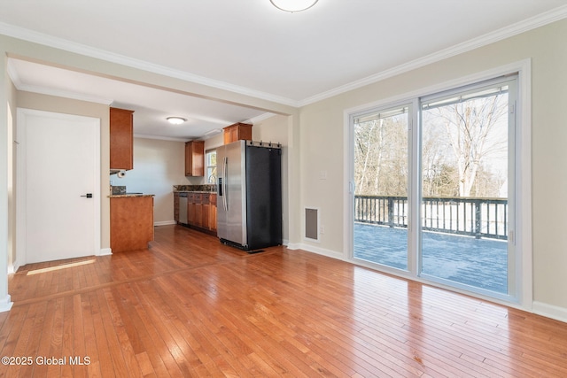 unfurnished living room featuring light hardwood / wood-style flooring and crown molding