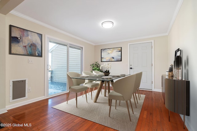 dining space featuring hardwood / wood-style floors and crown molding