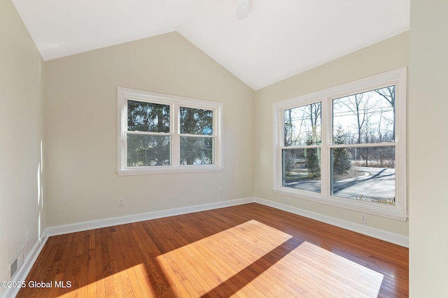 spare room featuring hardwood / wood-style floors and lofted ceiling