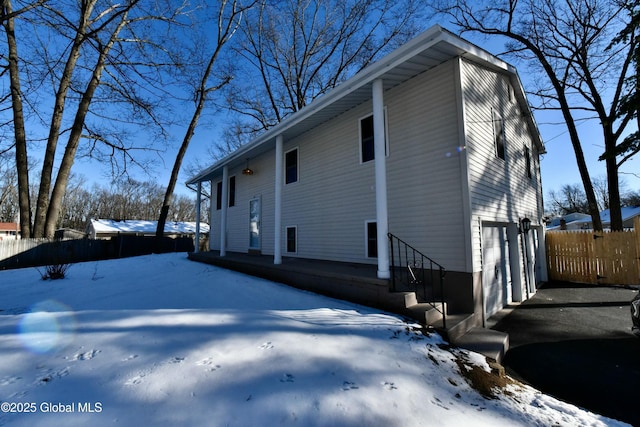 view of snowy exterior featuring a garage