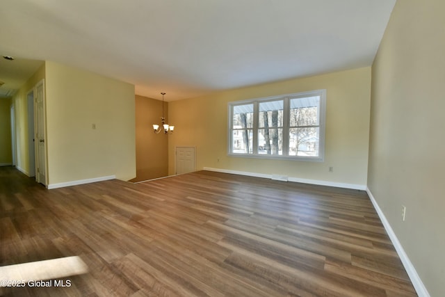 unfurnished living room featuring dark hardwood / wood-style flooring and a chandelier