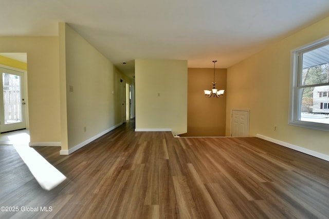 empty room featuring dark hardwood / wood-style flooring and an inviting chandelier