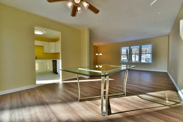 interior space featuring light wood-type flooring, white cabinetry, ceiling fan with notable chandelier, and decorative light fixtures