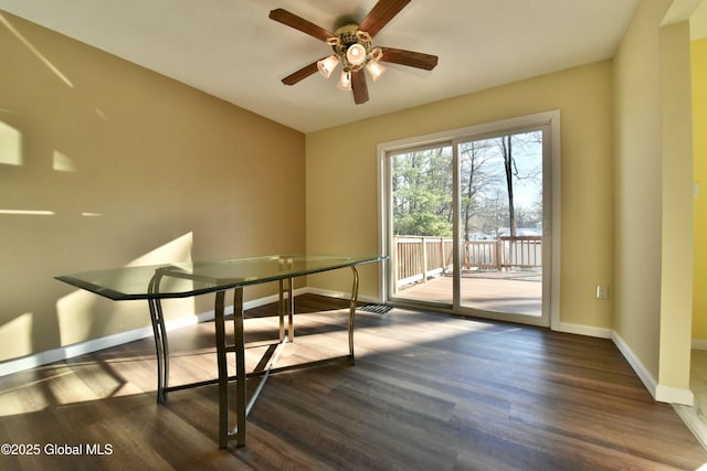 unfurnished dining area featuring ceiling fan and dark wood-type flooring