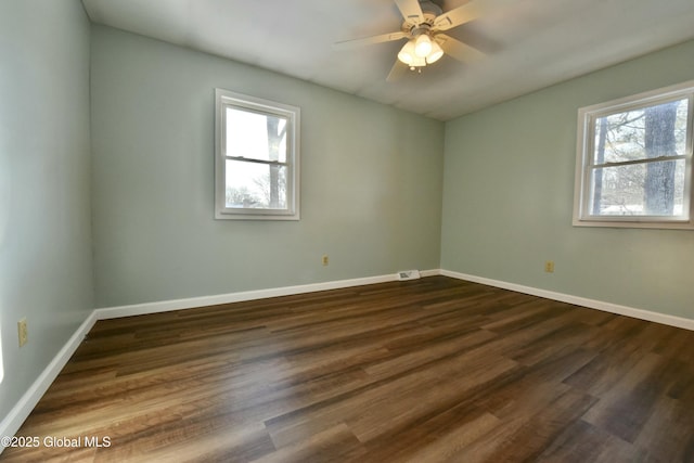 spare room with ceiling fan and dark hardwood / wood-style flooring