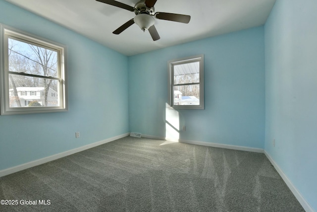 empty room featuring ceiling fan, plenty of natural light, and carpet floors