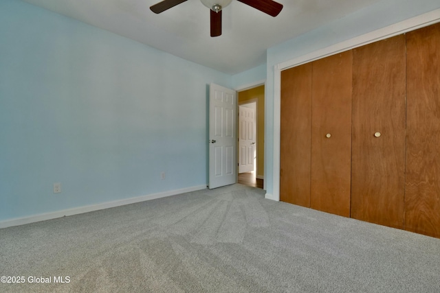 unfurnished bedroom featuring ceiling fan, a closet, and light carpet