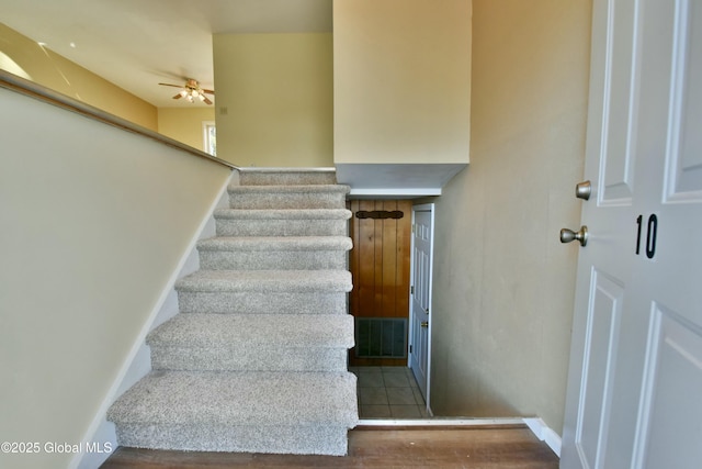 staircase featuring ceiling fan and tile patterned floors