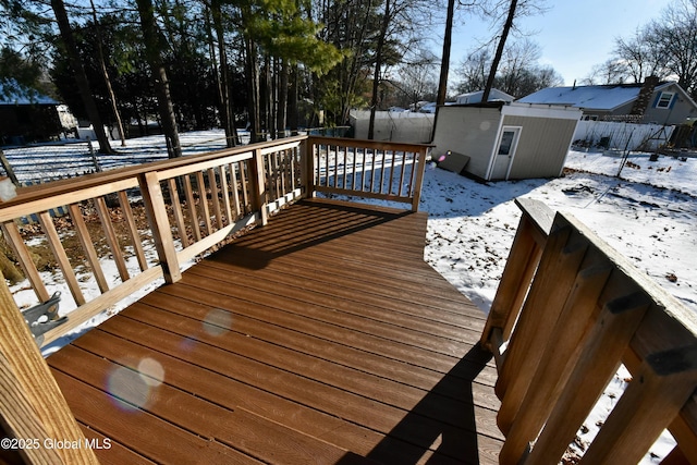 snow covered deck with a shed