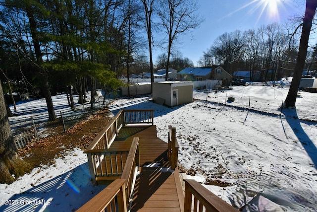 snowy yard with a storage shed