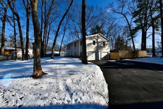 snow covered property with a garage