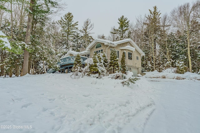 view of snow covered exterior featuring a garage and a wooden deck