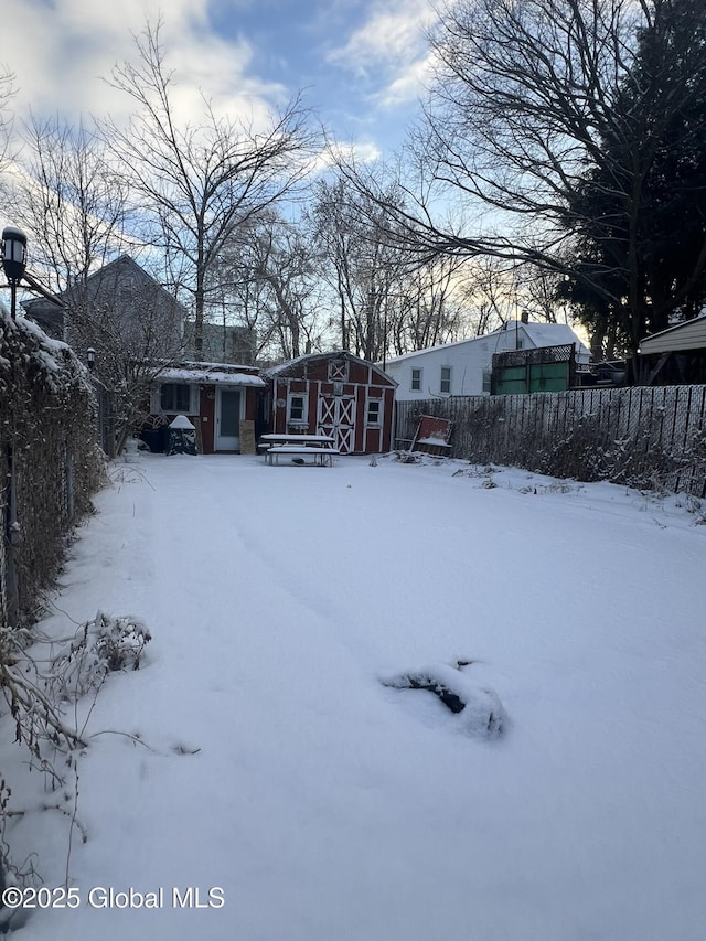 yard covered in snow with a shed