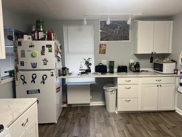 kitchen featuring white appliances, dark wood-type flooring, and white cabinets