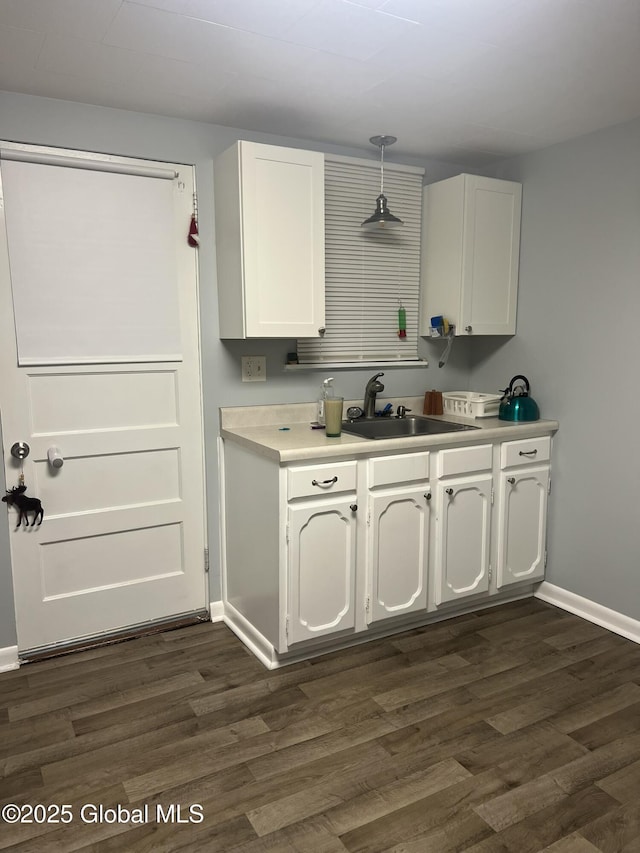 kitchen featuring white cabinetry, dark hardwood / wood-style floors, sink, and decorative light fixtures