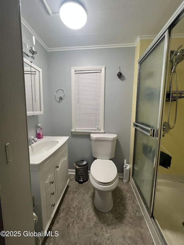 bathroom with vanity, toilet, crown molding, and a shower with shower door