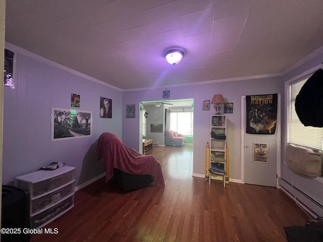 living area featuring hardwood / wood-style floors, crown molding, and baseboard heating