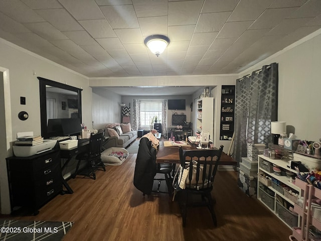 dining area with crown molding and dark wood-type flooring