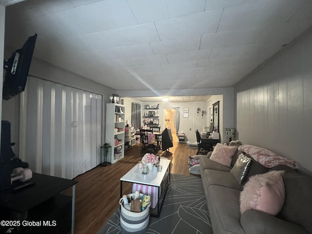 living room featuring dark wood-type flooring and built in shelves