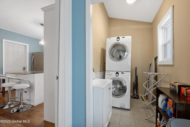 washroom featuring stacked washer / dryer and light hardwood / wood-style floors