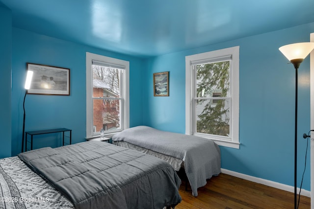 bedroom with dark wood-type flooring and multiple windows