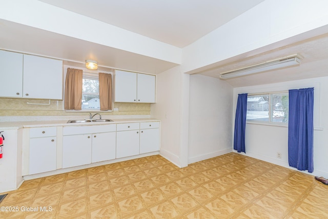 kitchen featuring sink, white cabinets, and tasteful backsplash