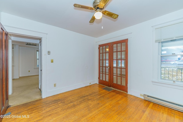 unfurnished room with light wood-type flooring, ceiling fan, french doors, and a baseboard radiator