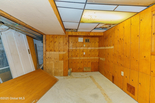 basement with carpet flooring and wood walls