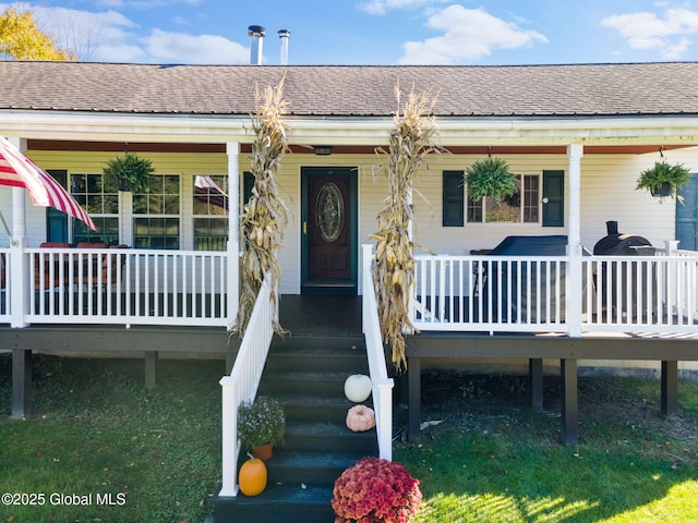 view of exterior entry featuring covered porch