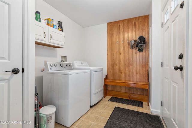 clothes washing area with cabinets and washing machine and clothes dryer