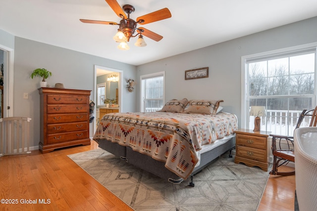 bedroom featuring light hardwood / wood-style floors, ensuite bathroom, and ceiling fan