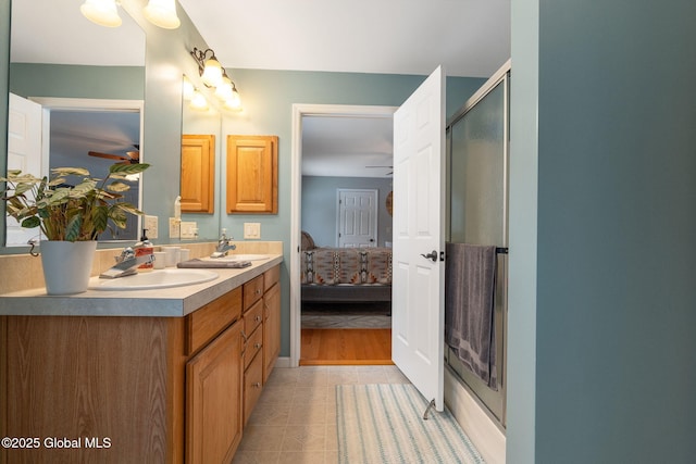 bathroom with walk in shower, vanity, and tile patterned floors