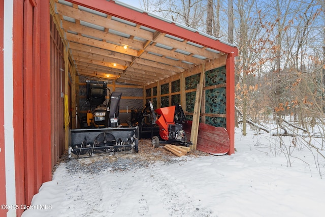 snow covered structure featuring a carport