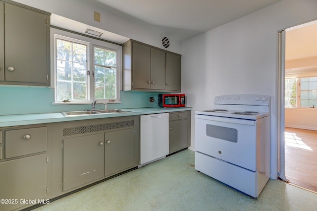 kitchen featuring white appliances, gray cabinets, and sink