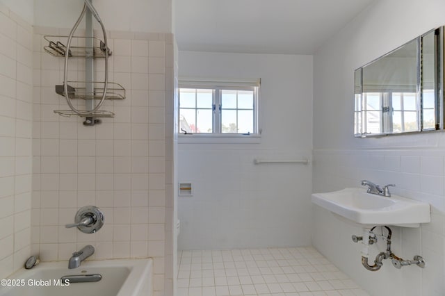 bathroom featuring tiled shower / bath, tile patterned floors, tile walls, and sink