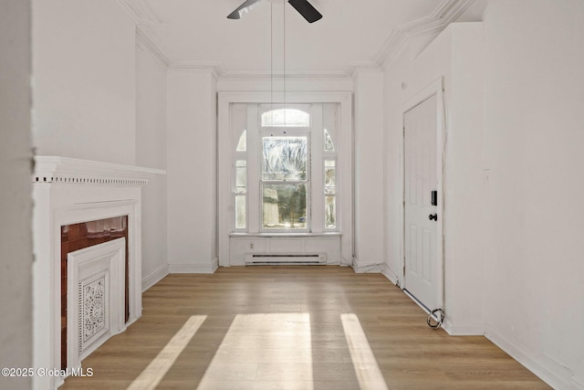 unfurnished living room featuring a baseboard heating unit, ornamental molding, ceiling fan, and light hardwood / wood-style flooring